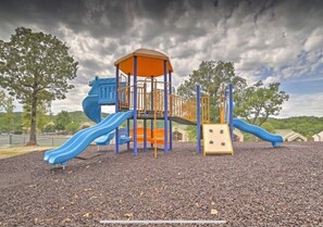 A playground with a blue slide, orange climbing structure, and a covered play area.