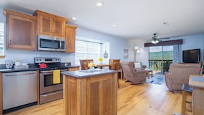 A modern kitchen with wooden cabinets, stainless steel appliances, and a central island.