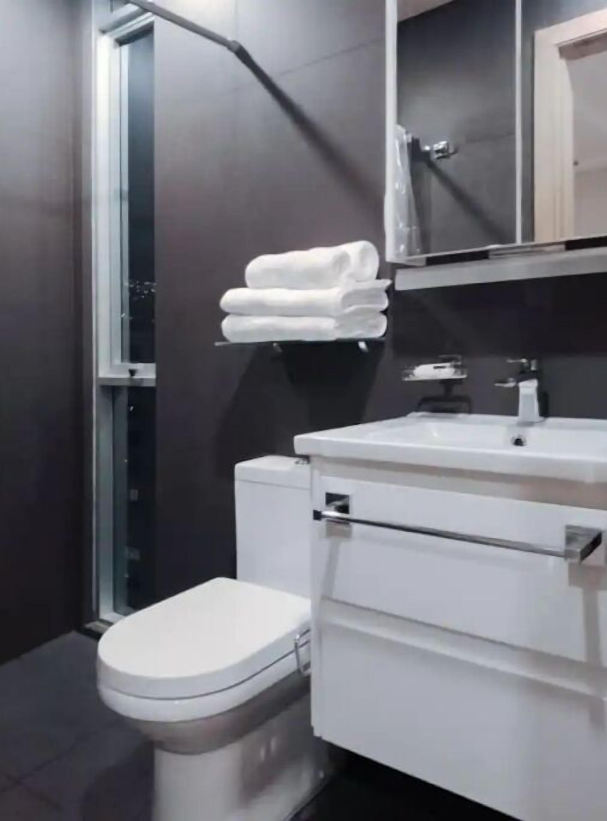 Un bagno moderno con il water, un lavandino e uno specchio.
