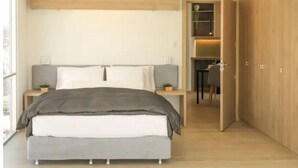 A modern bedroom with a bed, bedside tables, and a wardrobe.