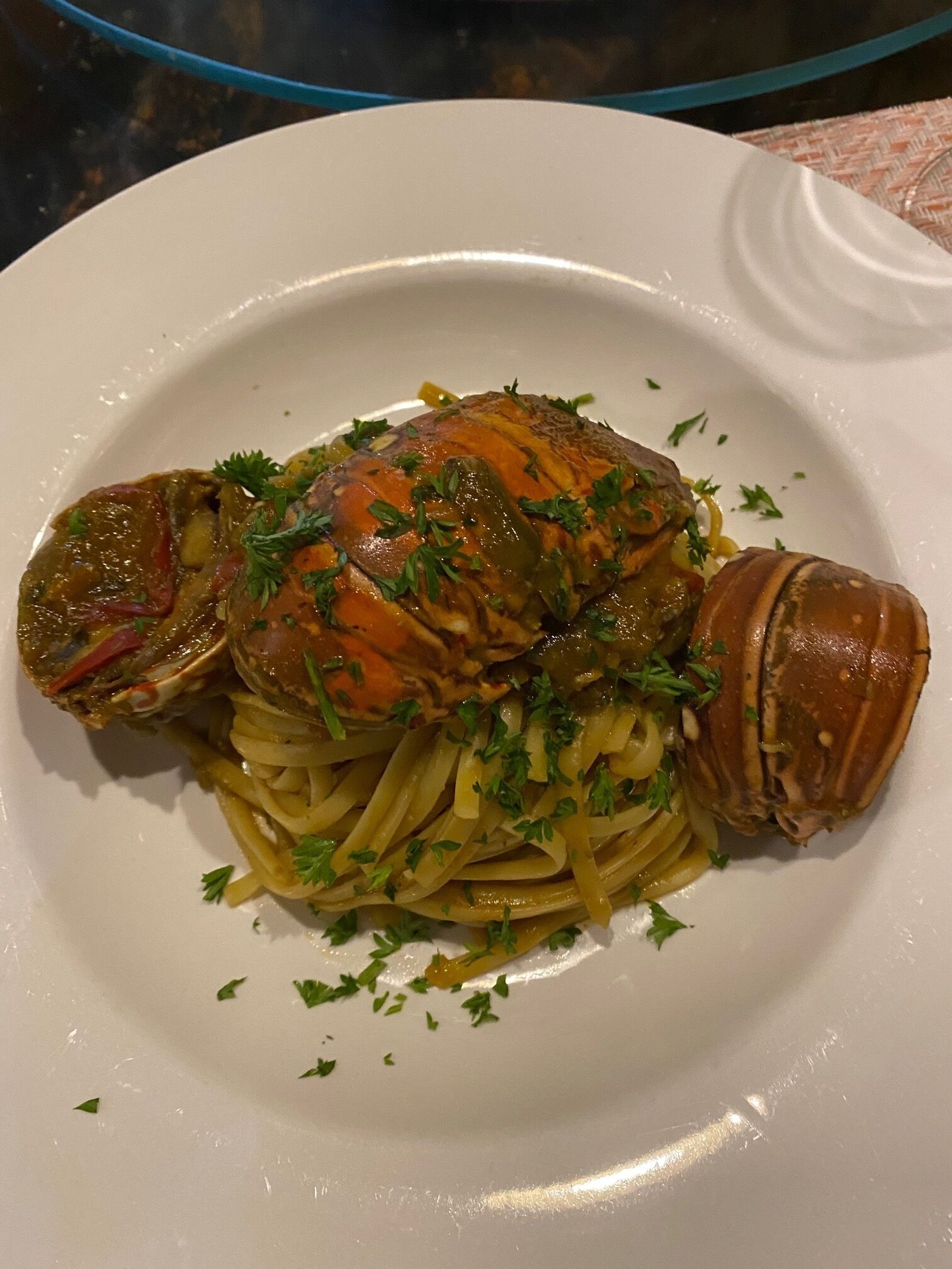 Ein Teller Pasta mit Hummer Schwanz, garniert mit Petersilie.