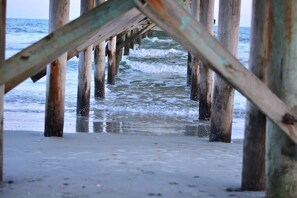 A pier with wooden supports extending into the water. - Fairway to the Beach (Myrtle Beach)