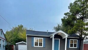 A residential house with a garage, a front porch, and a small front yard. - NEW 39th Street hot tub (Oklahoma City)