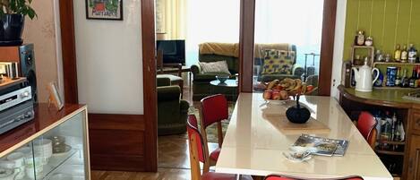 Un comedor con una mesa de madera, sillas rojas y una lámpara colgante.