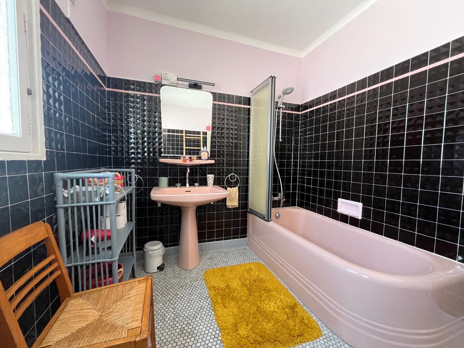 Un baño con bañera, lavamanos y espejo.