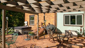 A patio with a brick floor, metal chairs, a table, and a grill. - Baladerry Inn (Gettysburg)