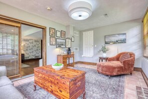 Un salon avec une table basse en bois, un fauteuil confortable et une cheminée.