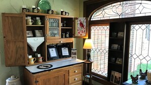 A kitchen with wooden cabinets, a coffee maker, and a window with a view of chickens outside. - Baladerry Inn (Gettysburg)