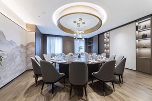 A modern dining room with a round table, six chairs, and a chandelier. - Hequn Hotel (Xinchang)
