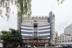 A multi-story building with a central entrance, large windows, and a modern architectural design. - Hequn Hotel (Xinchang)