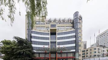 Un edificio de varios pisos con fachada curva, amplias ventanas y una entrada destacada.