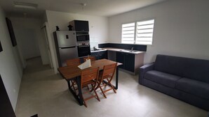 Ein kompakter Wohnbereich mit Küchenzeile, Essplatz und einer Couch.
