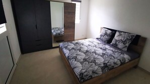 Ein Schlafzimmer mit einem Bett, einem Kleiderschrank und einem Spiegel.