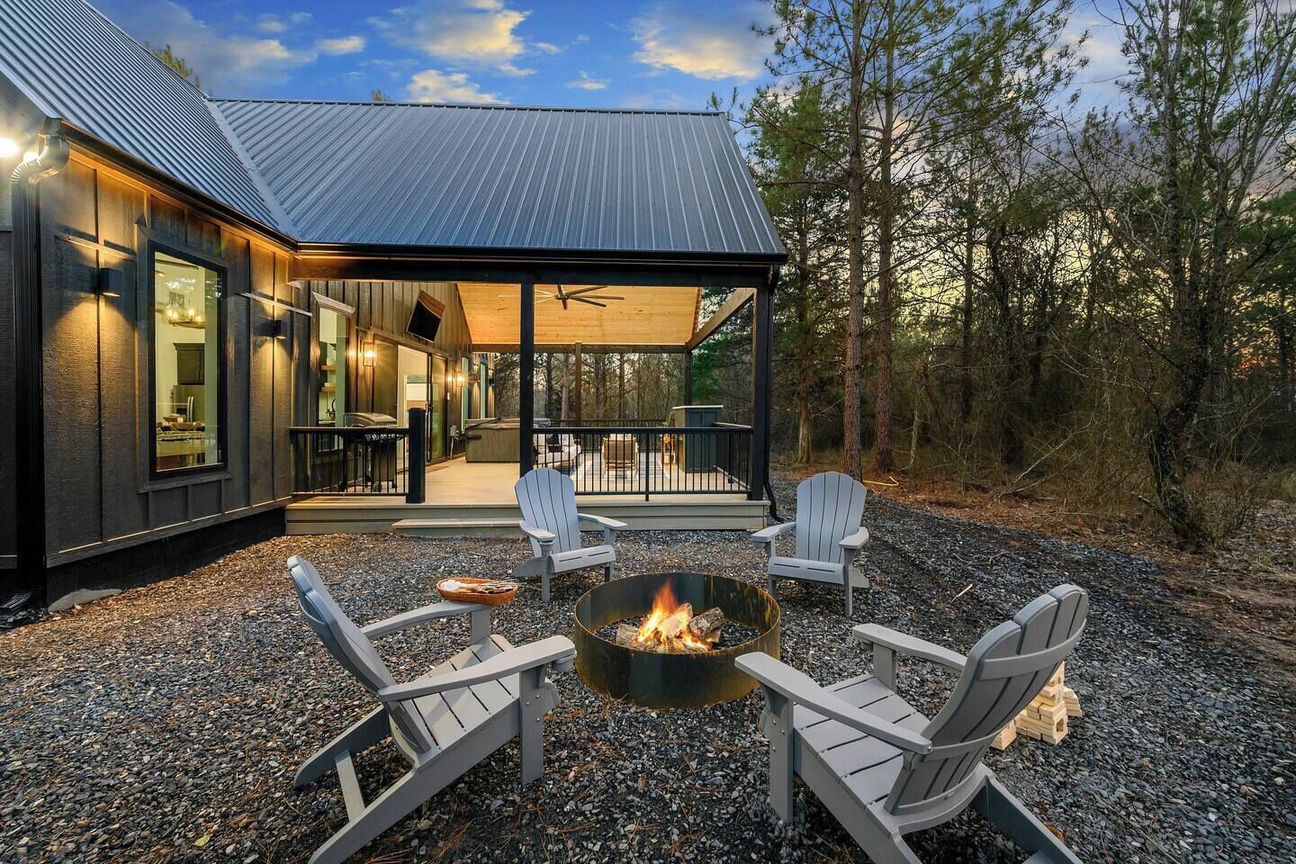 A modern building with a covered patio area, outdoor seating, and a fire pit.