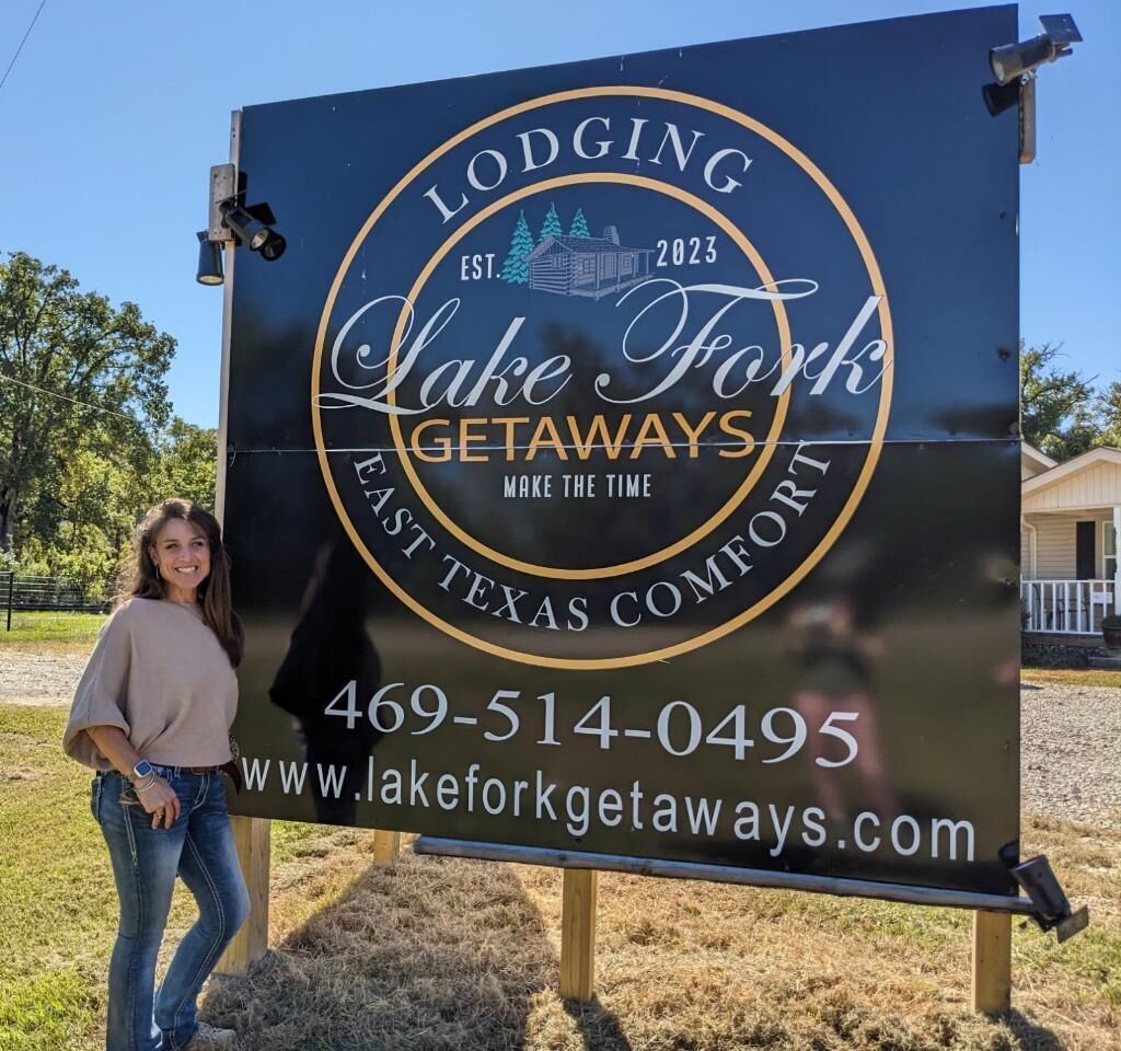 Une enseigne pour Lake Fork Getaways, un établissement proposant des hébergements dans l’est du Texas, avec les coordonnées et l’adresse du site web.