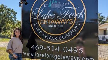 Une enseigne pour Lake Fork Getaways, un établissement proposant des hébergements dans l’est du Texas, avec les coordonnées et l’adresse du site web.