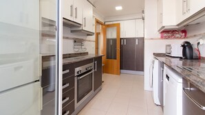 A modern kitchen with stainless steel appliances, a built-in oven, and a dishwasher.