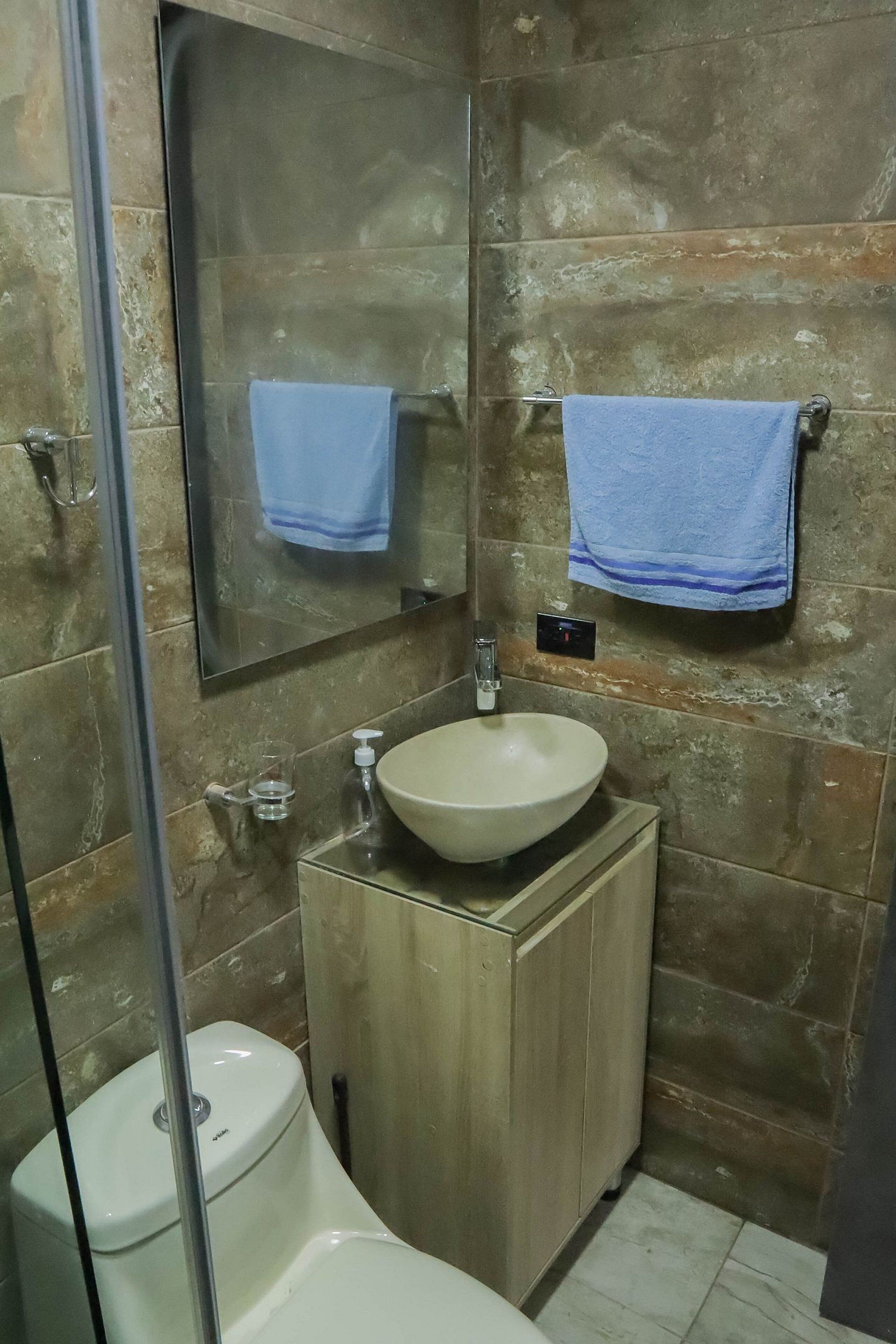 A bathroom with a sink, mirror, and two towels.