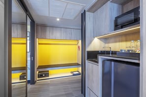 Une cuisine moderne dotée d’appareils électroménagers intégrés, d’un four à micro-ondes et d’un plan de travail orné de bouteilles.