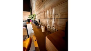 Pared de madera con una planta en maceta y un florero de vidrio.