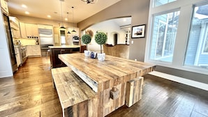 A modern kitchen with a large island, wooden flooring, and pendant lighting. - Elkhart Lake Oasis - 25 Acres, Hot Tub & Orchard - 15 Min to Road America (Plymouth)