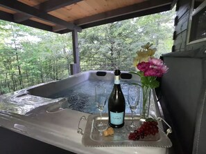 Tinaco con una botella de vino, copas y flores.
