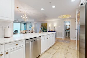 Enjoy cooking in this well-equipped kitchen with a central island, stainless steel appliances, and ample cabinetry.