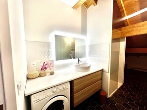 Een douche, een haardroger, handdoeken, toiletpapier