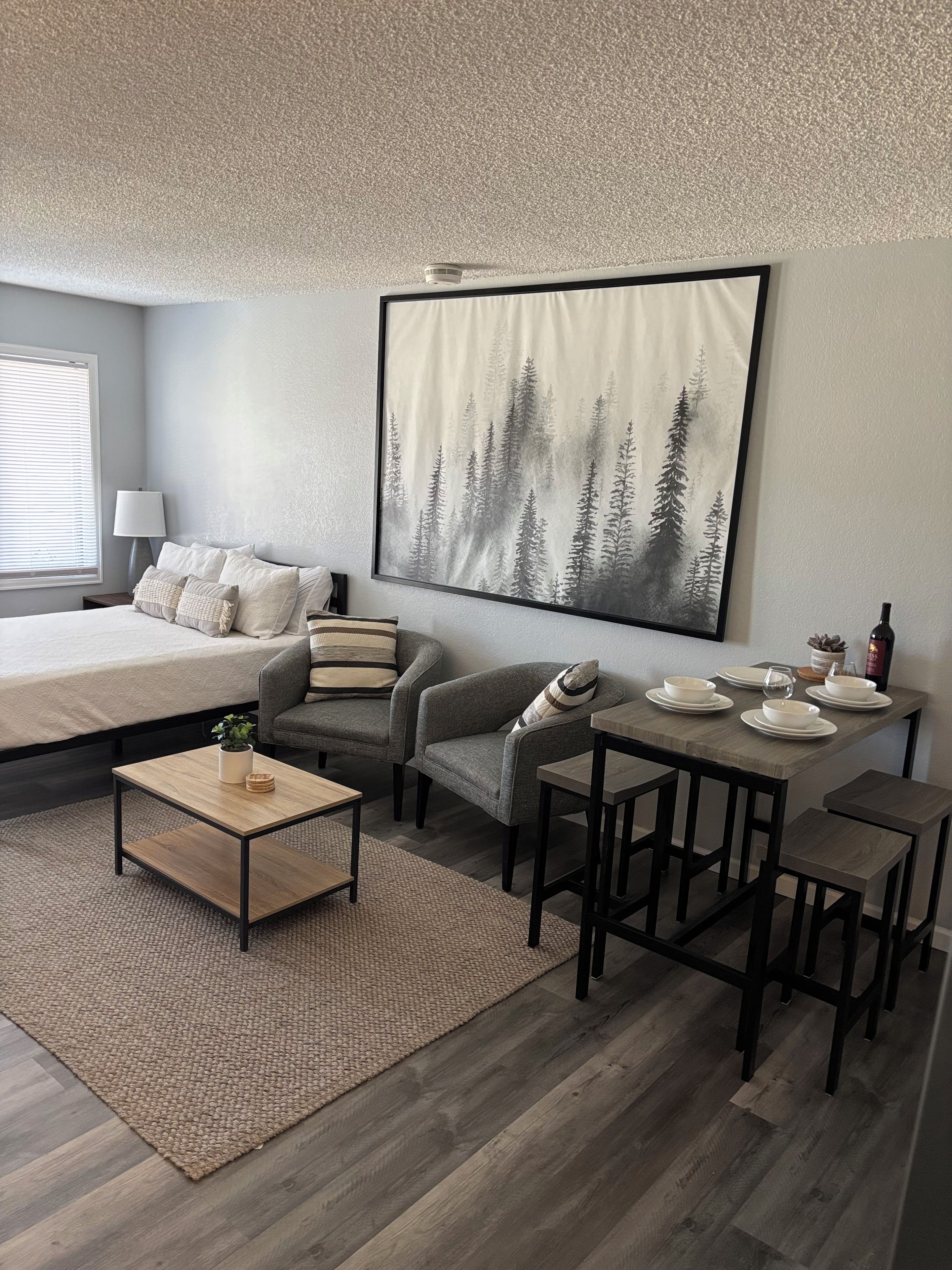 Une chambre moderne comprenant un lit, un canapé, une table basse et un coin repas avec une table et des chaises.