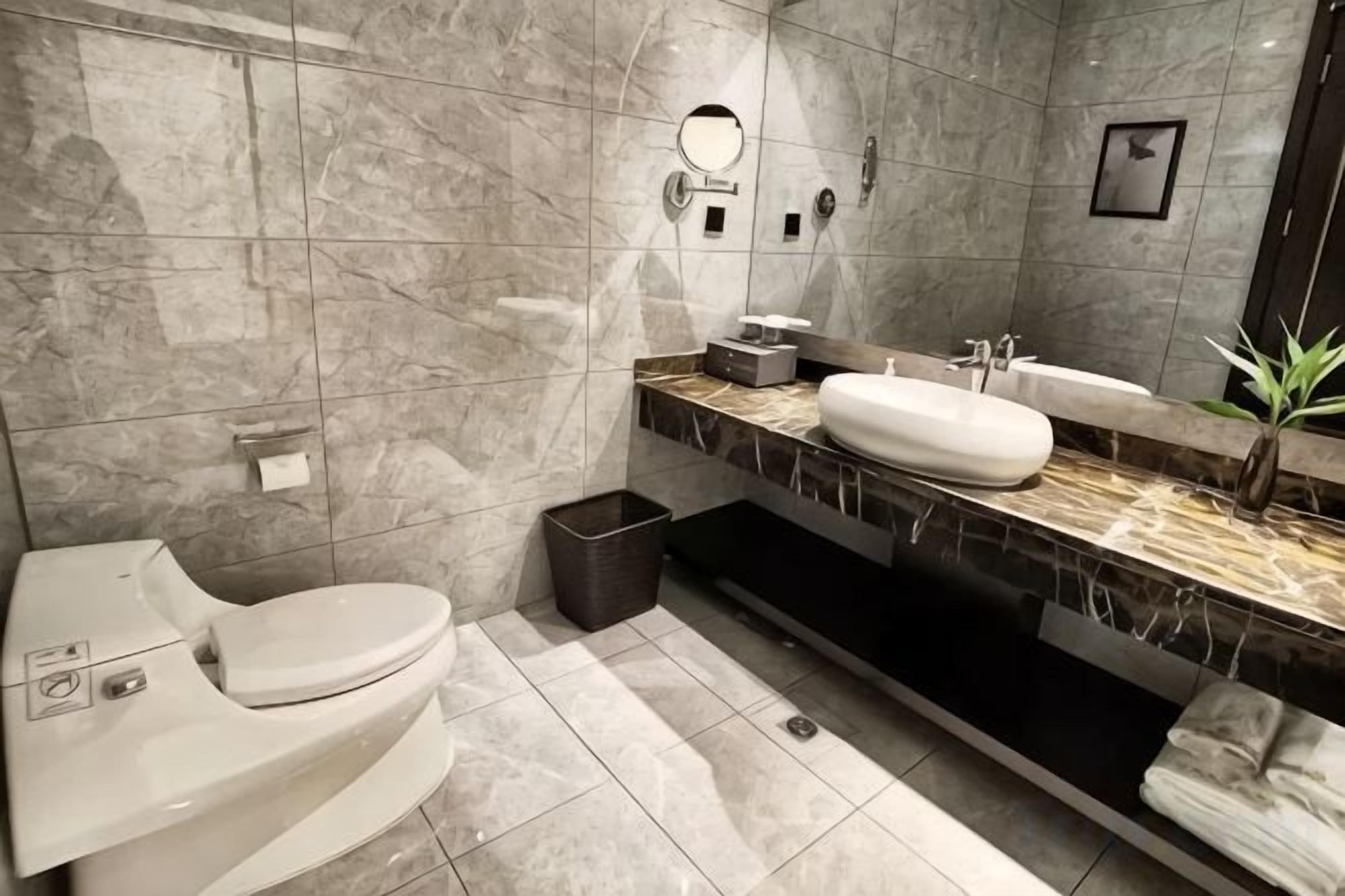 Un baño moderno con inodoro, lavabo y espejo.