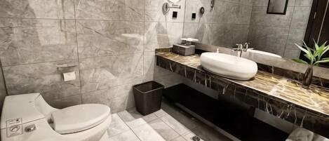 Un baño moderno con inodoro, lavabo y espejo.