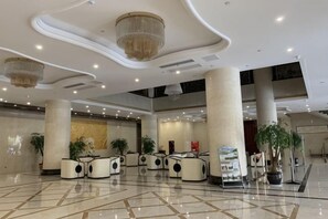 A spacious lobby with a high ceiling, large columns, and modern seating arrangements. - Yueyuan International Hotel (Ningguo)