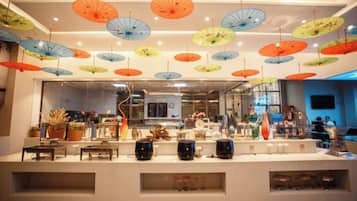 A hotel lobby with a reception desk, hanging umbrellas, and a view of the interior.