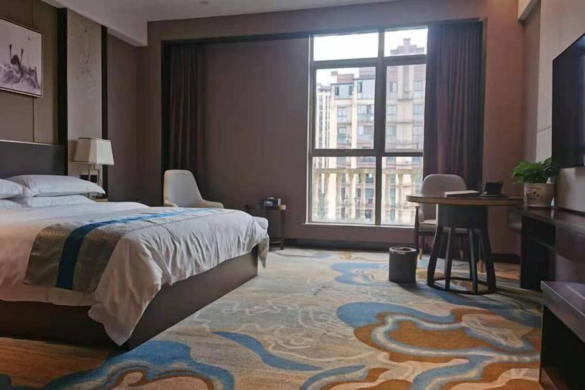 Relax in this stylish room with a large bed, a small table for work or dining, and a TV for entertainment.