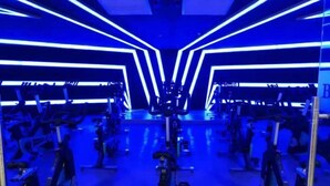 Une salle de sport équipée de matériel d’exercice et dotée de murs couverts de miroirs.