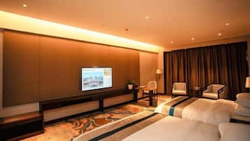 Habitación de hotel con una cama grande, un televisor en la pared, un escritorio con una silla y vista a la ciudad desde la ventana.