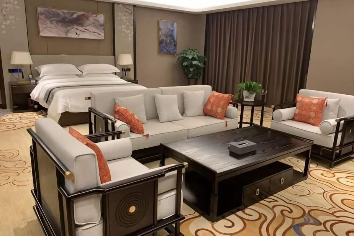 Une chambre d’hôtel avec un grand lit, un canapé, une table basse et un bureau.