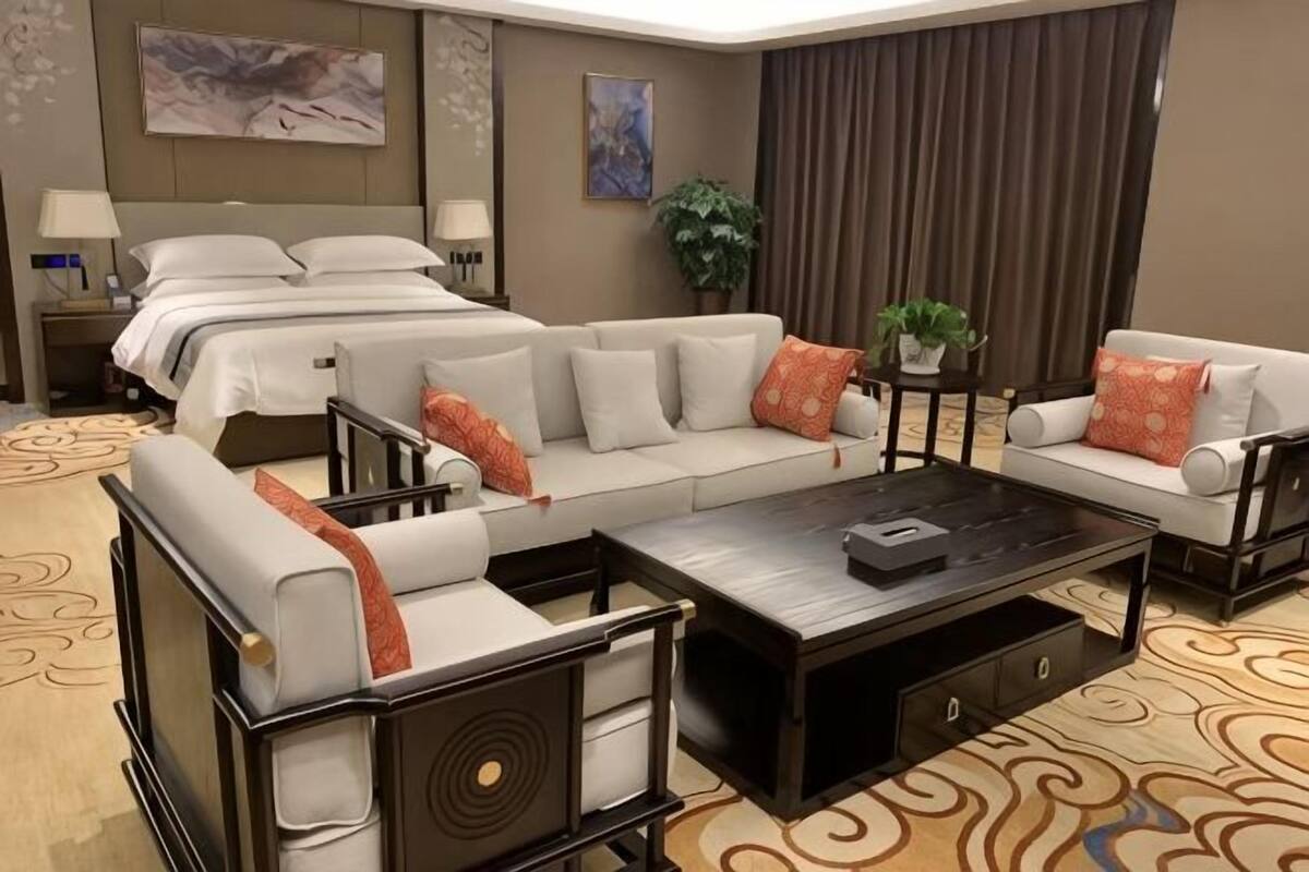 Une chambre dâhĂŽtel avec un grand lit, un canapĂ©, une table basse et un bureau.