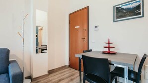 A dining area with a wooden table, black chairs, and a red decorative item on the table. - Al 13 Blu 2 - Lakeside L&b (Stresa)