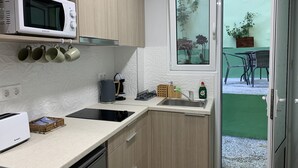 Cocina moderna con microondas, cafetera y lavabo. Se ve una ventana con vistas al exterior.