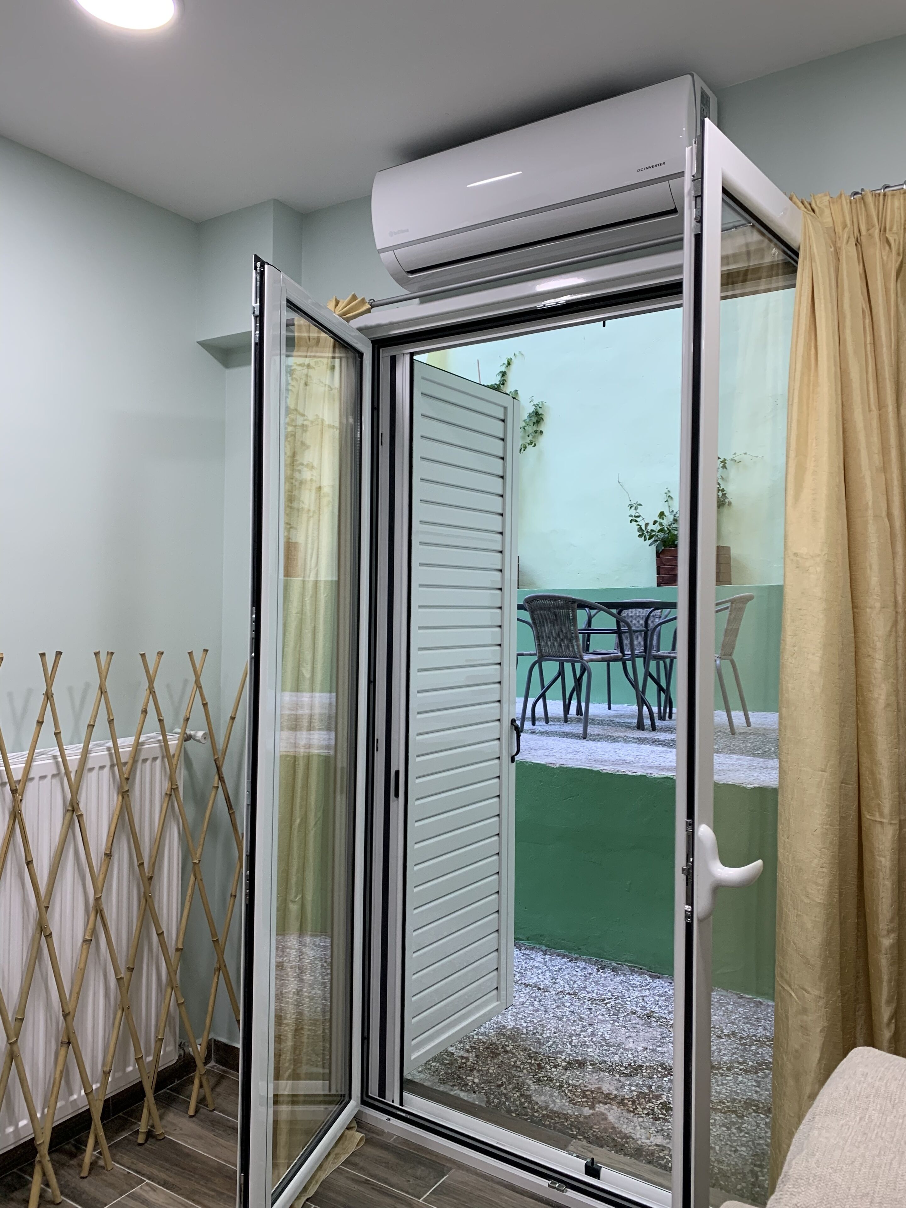 A room with a sliding glass door leading to an outdoor area with a table and chairs.