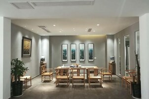 A conference room with a long table, chairs, and framed artwork on the walls.