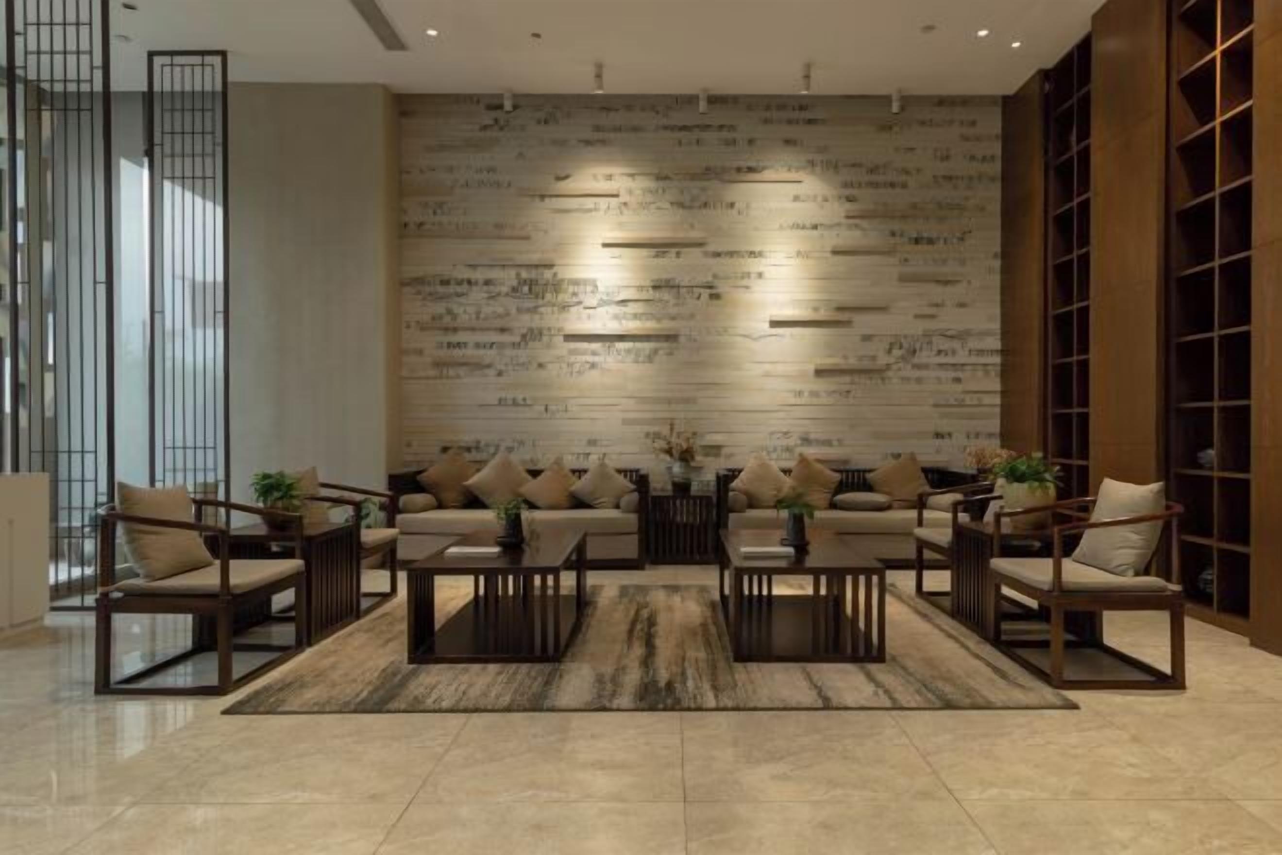 A modern living room with a sofa set, coffee tables, and a patterned wall.