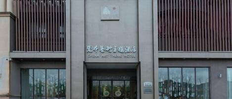 Das China Art Theme Hotel mit moderner Fassade, großen Glasfenstern und einem Schild mit dem Hotelnamen.