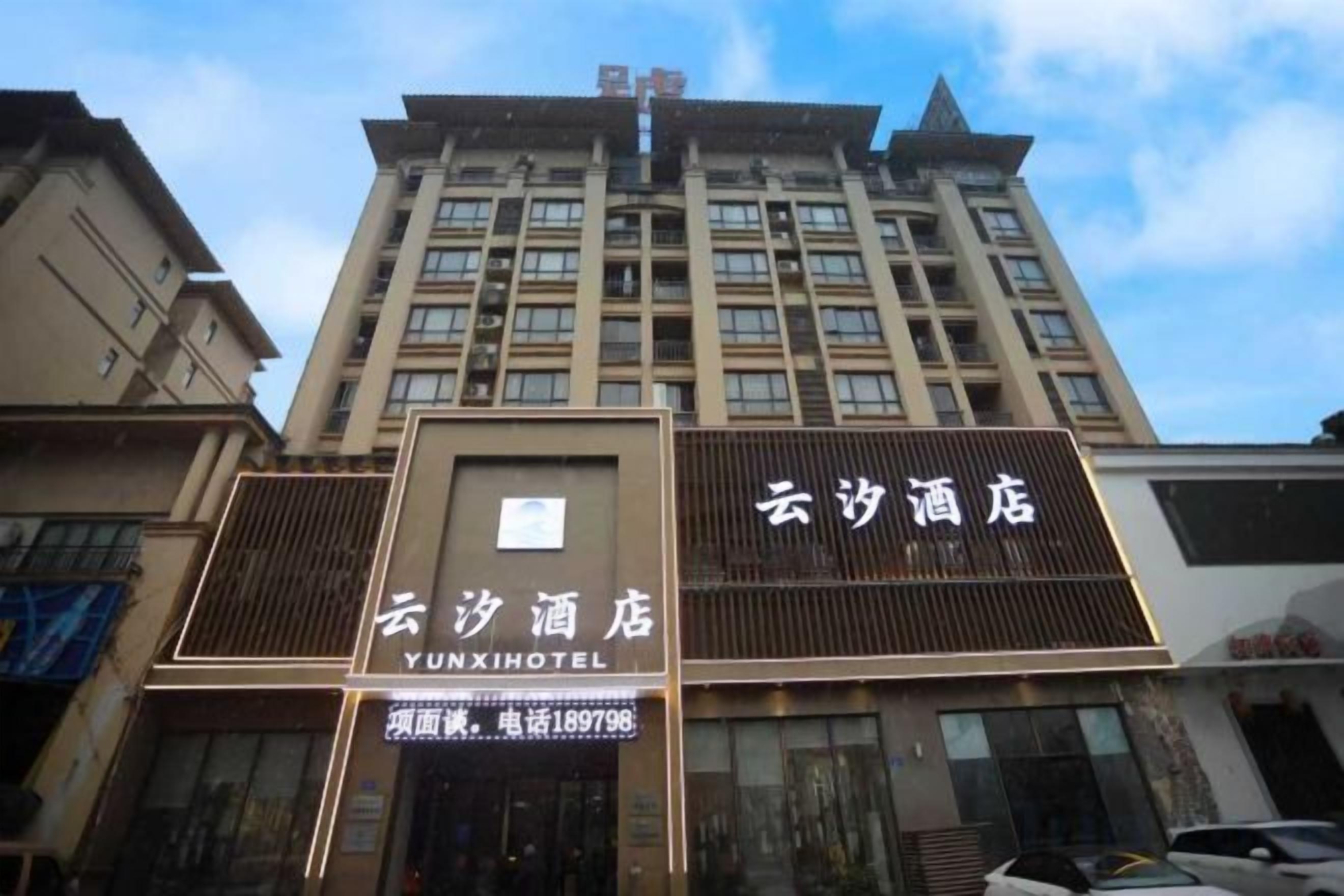 A hotel building with signage for 'Yunxi Hotel' and 'Yunxi Hotel' in English.