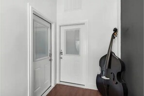 Stylish hallway with a black cello and two doors.