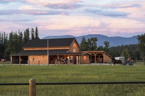 Une grange en bois dotée d’une zone d’entraînement couverte et d’une écurie.
