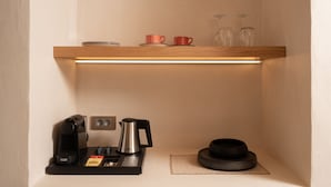 A compact kitchenette with a coffee machine, a kettle, and a tea set. - Acanthus Oia-Suites With Private Hot Tub (Santorini)