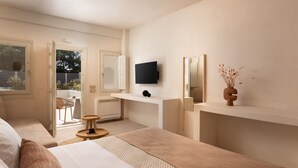 A modern hotel room with a large bed, a desk, a TV, and a balcony with a view of the outdoors. - Acanthus Oia-Suites With Private Hot Tub (Santorini)