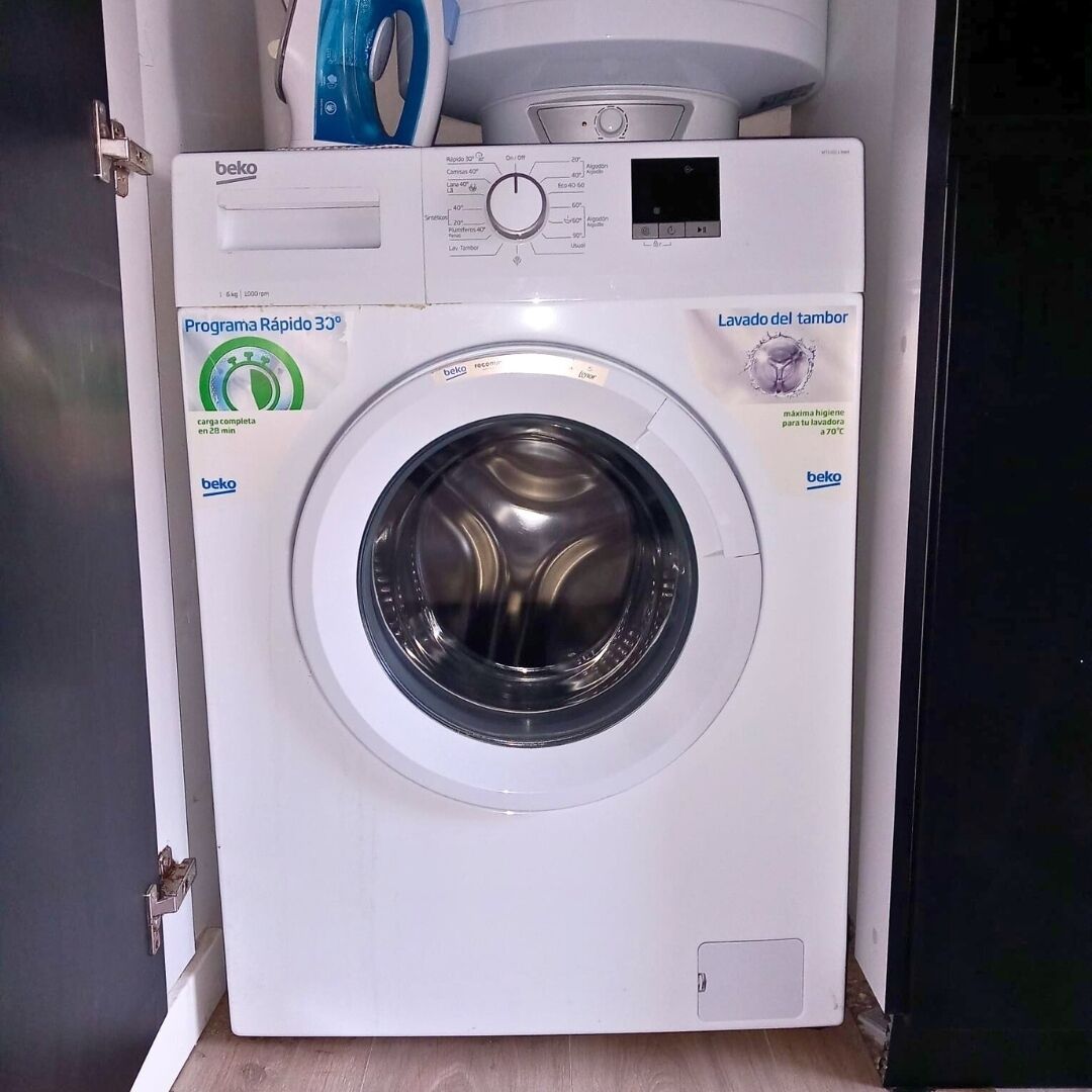 A front view of a white front-loading washing machine with a control panel, a digital display, and a label indicating a 30-minute cycle.
